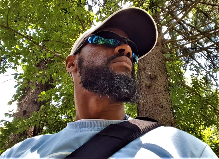  Taurus M. James (aka Coach T) standing by tree looking for campers at JAM Camp.